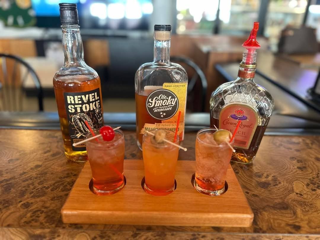 Whiskey cocktail flight on a wooden serving board